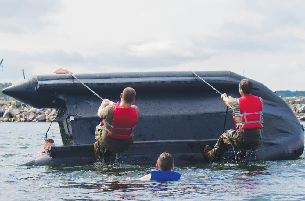 Army National Guard Soldiers with Charlie Troop, 1st Squadron, 172nd Cavalry Regiment (Mountain), 86th Infantry Brigade Combat Team (Mountain), and Vermont Army National Guard right a zodiac boat during boat during boat capsizing training in Burlington, Vt.