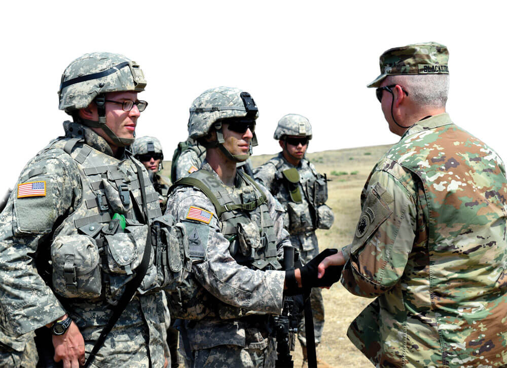 BG Tom Blackstock presents coins to SGT Caleb Taylor and CPL Andrew Foregone of the Georgia National Guard's 810th Engineer Company at the Varian Training Area.