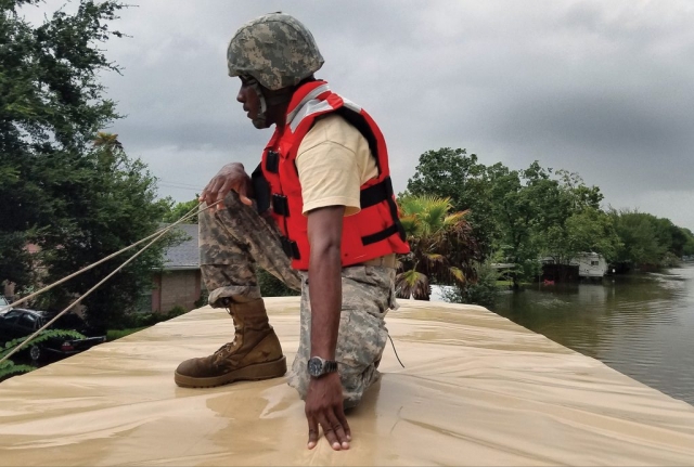 A Soldier With The Texas Army National Guard keeps an eye on rising floodwaters in a Houston neighborhood while working to rescue those stranded by Hurricane Harvey. More than 12,000 members of the Texas National Guard were called out to support local authorities in response to the storm.
