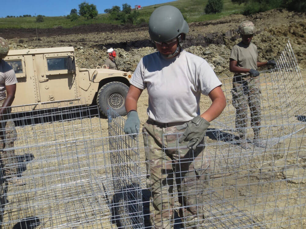 SPC Kimberly Hurtado lines Gabion baskets in a designated row for a berm.