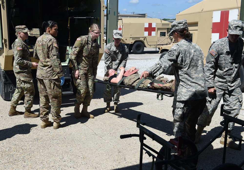 Soldiers from the Iowa Army National Guard 209th and 134th Medical Companies practice transferring a patient from an ambulance into the Sustainment Training Center.