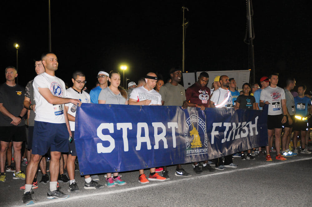 Soldiers of the 35th Infantry Division gather with the ‘Start Finish’ banner at the start of the Kansas City Marathon Shadow 10k run held at Camp Arifjan, Kuwait.