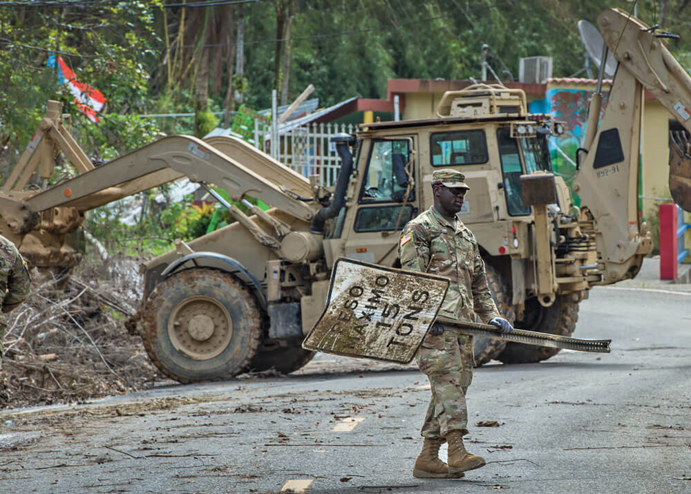 PFC Raiquan Wade of Charleston, South Carolina helps clear debris from the roads near Cayey, Puerto Rico in the aftermath of Hurricane Maria.