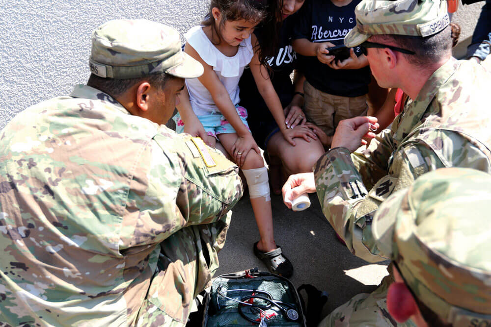 PFC Mykalob Stephens and members of Oklahoma National Guard’s Company D, 1st Battalion, 179th Infantry Regiment, 45th Infantry Division, bandage minor wounds received by residents during Hurricane Harvey in Port Arthur, Texas.