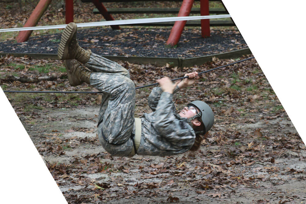 A Cadet moves through the ropes section of a team development obstacle course.