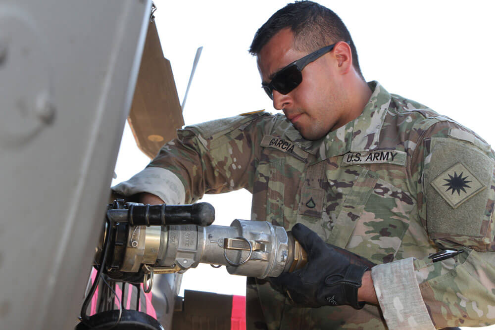 PFC Vicente Garcia of Echo Company, 1st Battalion, 140th Aviation Regiment, California Army National Guard, pumps fuel into a UH-60 Black Hawk at Coalinga Municipal Airport in Fresno County.