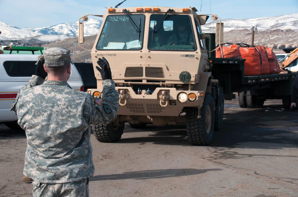 SGT Chase Howard, 1859th Transportation Company, Nevada Army National Guard, ground guides an M1088 light medium tactical vehicle transporting sandbags to Lemmon Valley during the flood response.