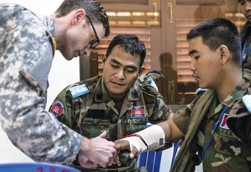 CPT Derek Derkacs explains to members of the Royal Cambodian Armed Forces how to splint a fracture.