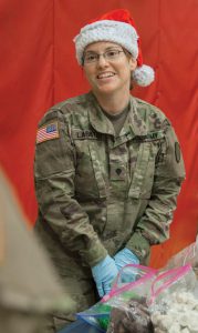 SPC Bridget Lasater passes out cookies to the children of St. Michael, Alaska, during Operation Santa 2017.