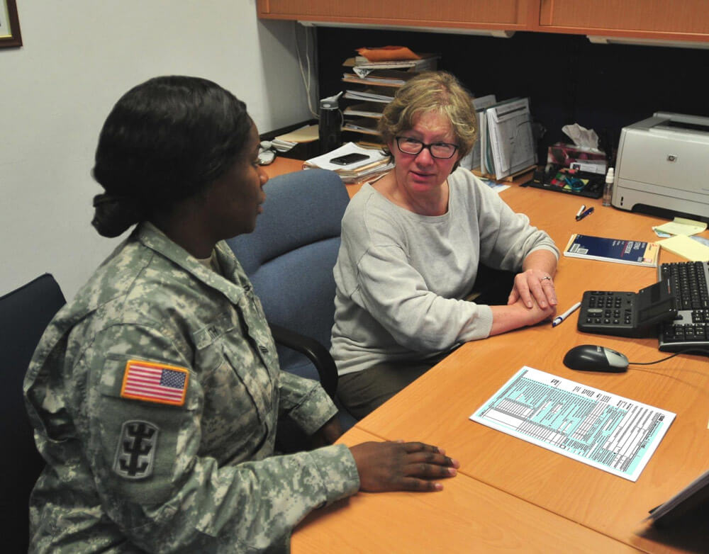 Tamara Chapman (right) a 21st Theater Sustainment Command tax preparer, helps a service member prepare her tax return. Army National Guard Photo by Brandon Beach