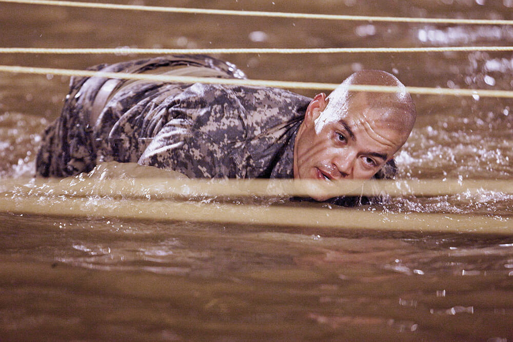 Texas National Soldier SGT Jay-Jay Janabajal moves through the water obstacle at Kirby Field during the Ranger Training Assessment Course. Kirby Field is similar to the U.S. Army Ranger School’s Malvesti Course. U.S. Army Maneuver Center of Excellence photo by Ashley Cross.