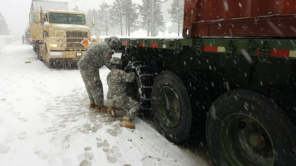 Soldiers from the 1113th Transportation Company, California Army National Guard, check their vehicle’s snow chains as they drive through inclement weather during Operation Patriot Bandoleer 2017. Army National Guard photo by CPT Howard Knapp.