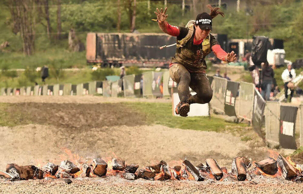 2LT Keppner jumps over a fire obstacle in the last leg of the Seattle Spartan Super Race. Photo courtesy of 2LT Julie Keppner.