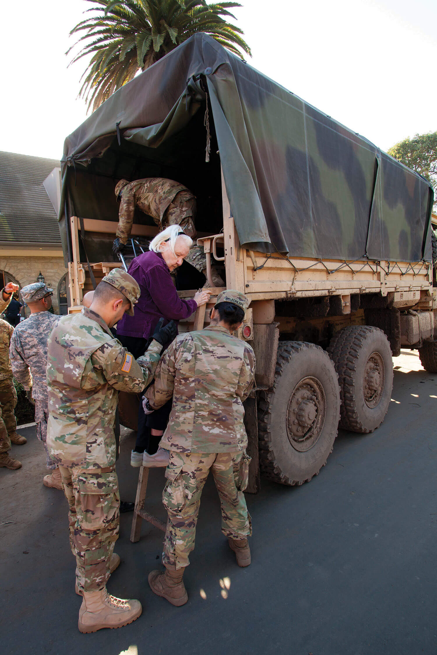 Soldiers from the California National Guard’s 1114th Composite Transportation Company help a 90-year-old woman climb up a ladder and into the back of their light medium tactical vehicle (LMTV) after evacuating the woman from her Montecito, Calif., neighborhood to a centralized drop-off point, Jan. 11, 2018. Massive mudslides left the community in ruins after soil-stabilizing vegetation was destroyed by the Thomas Fire. Heavy rains followed the blaze and caused mudslides that destroyed 73 buildings, damaged 466 buildings and killed at least 17 people. California National Guard photo by SrA Crystal Housman.