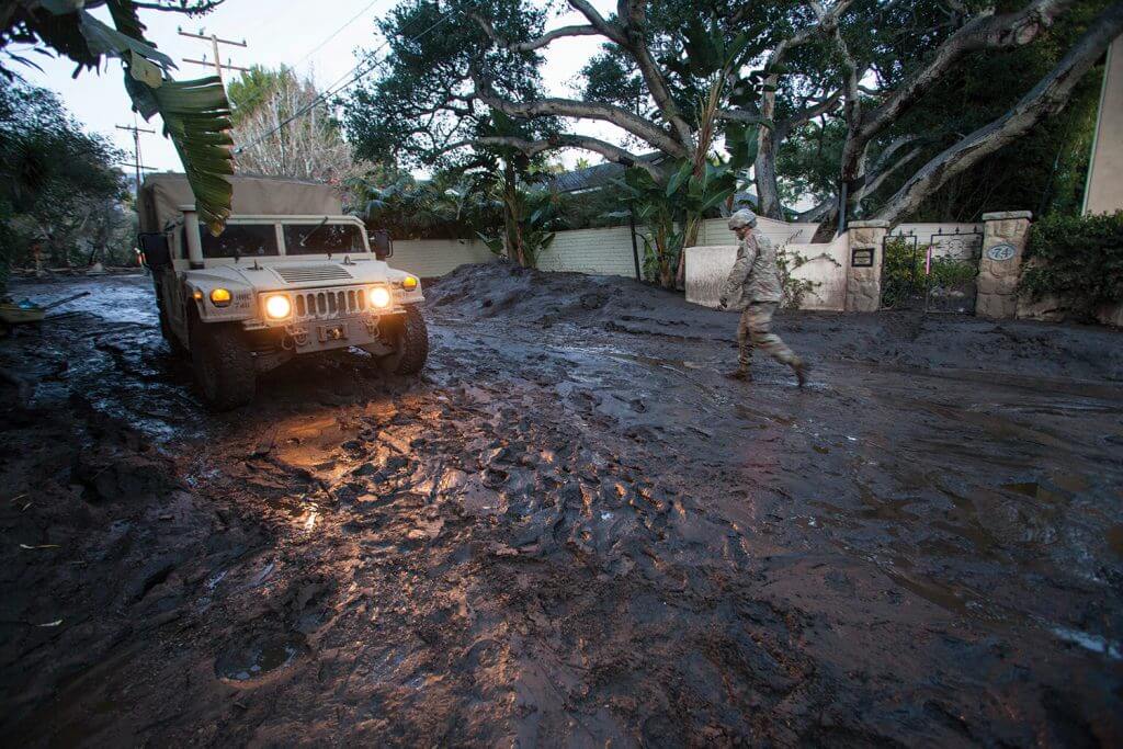 SGT Jose Paiz of the 1114th Composite Truck Company, California National Guard, walks back to a HMMWV, Jan. 12, 2018, after checking the depth of mud further down the street during a rescue mission in Montecito, Calif. California National Guard photo by SrA Crystal Housman