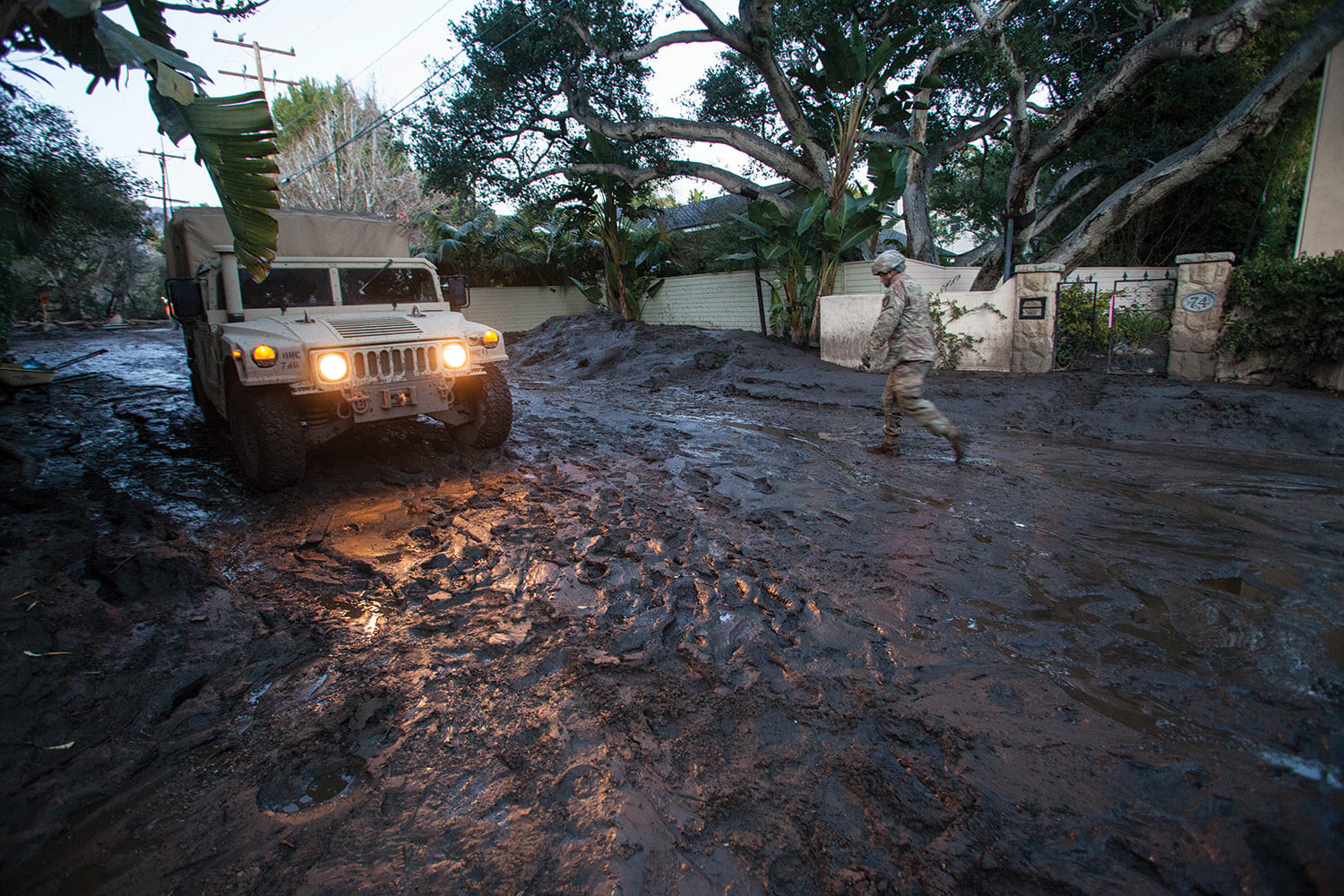 SGT Jose Paiz of the 1114th Composite Truck Company, California National Guard, walks back to a HMMWV, Jan. 12, 2018, after checking the depth of mud further down the street during a rescue mission in Montecito, Calif. California National Guard photo by SrA Crystal Housman.