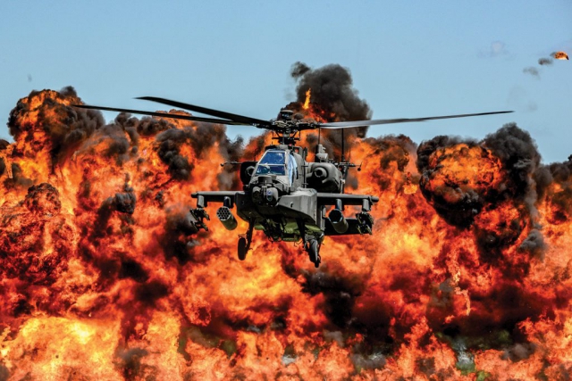 An AH-64D Apache Attack Helicopter, assigned to the 1-151st Attack Reconnaissance Battalion, flies in front of a wall of fire during the South Carolina National Guard Air and Ground Expo at McEntire Joint National Guard Base, S.C., May 6, 2017. The expo is a combined arms demonstration that showcases the abilities of South Carolina National Guard members. It also offers opportunities for the South Carolina Guard to express its thanks for the support shown by fellow South Carolinians in the surrounding community. South Carolina National Guard photo by Tech Sgt Jorge Intriago.