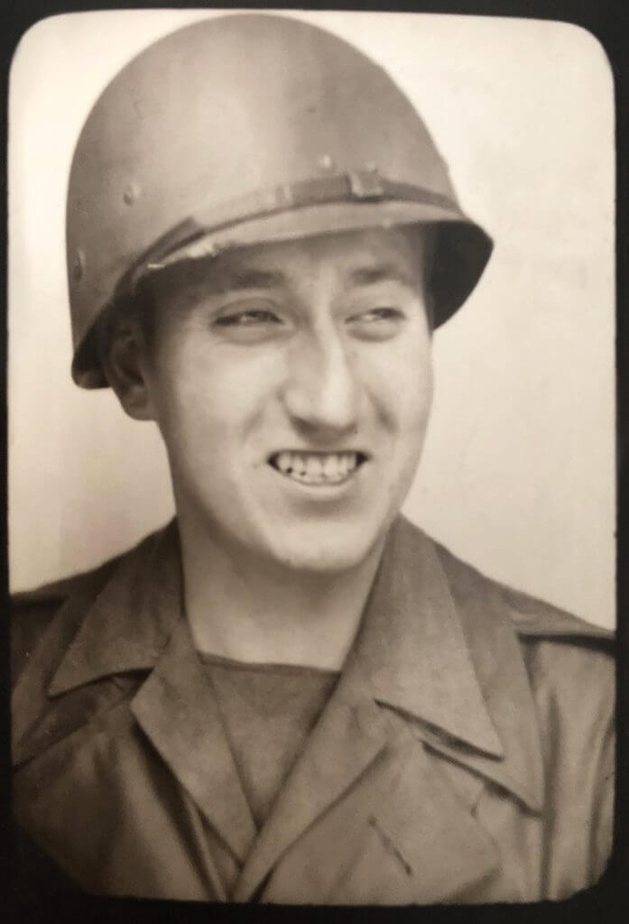 A 1945 photo of Angle shows the dent in his helmet where a German bullet shot at him by Nazi soldiers grazed past his head.