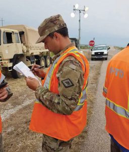 SSG Jeremy Warnick reviews a map while manning a roadblock in Pocahontas, Ark. Photos courtesy Arkansas Army National Guard