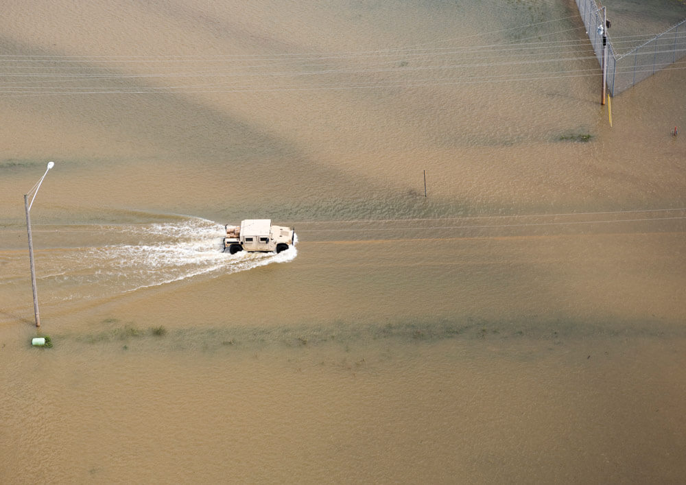 Arkansas Army National Guard Soldiers drive across a flooded highway in Pocahantas, Ark., while working to keep residents off the main thoroughfare. Arkansas Army National Guard photo by Zac Lehr