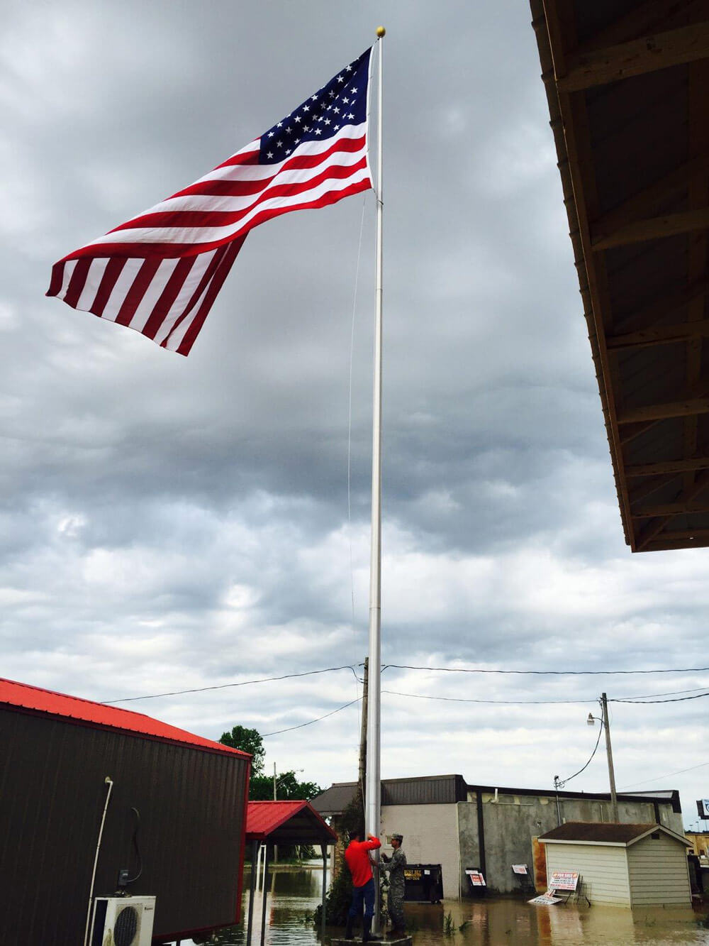 SFC Brandon Hassell and civilian Chad Overman raise the American Flag as a sign of hope to the weary residents of Pocahontas. Photos courtesy Arkansas Army National Guard