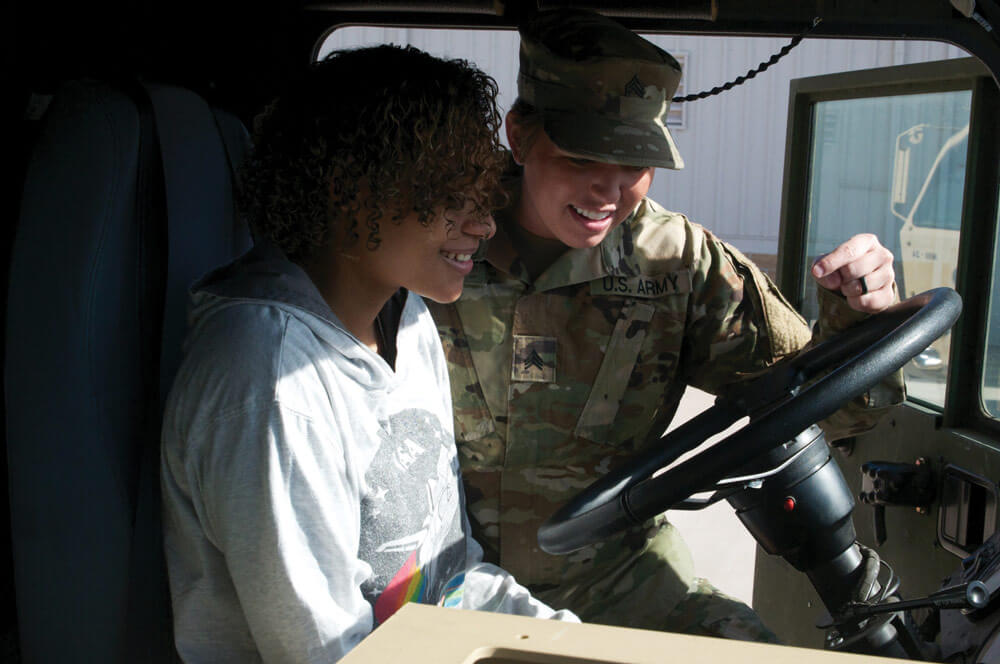 SGT Heather Davis, Oklahoma Army National Guard, shows Adrian Hinton the ins and outs of a fuel tanker at the Armed Forces Reserve Center in Norman, Okla. Oklahoma Army National Guard photos by SGT Bradley Cooney