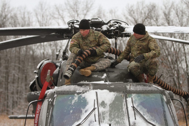 Two Missouri Army National Guard UH-60 helicopter mechanics, SGT Christopher Parsons (left) and PFC Austin Villhard from Detachment 1, Company D, 1-106th Aviation, defrost a UH-60 Black Hawk helicopter during an Annual Training exercise at Camp Clark, in Nevada, Mo. Missouri Army National Guard photo by SGT Emily Finn