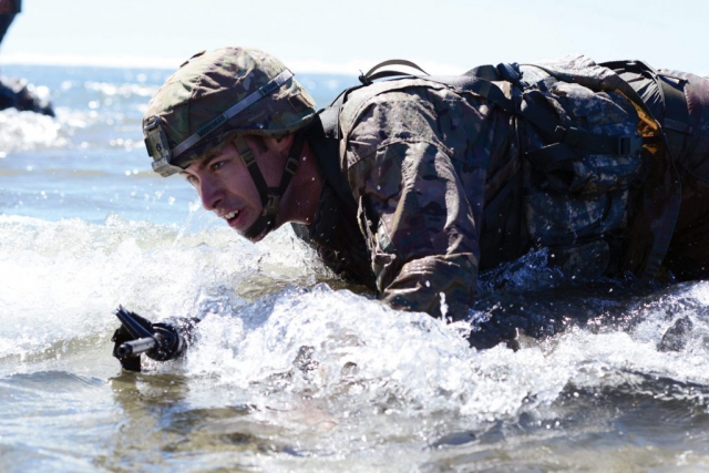 Oregon Army National Guard SGT Dane Moorehead, with B Troop, 1st Squadron, 82nd Cavalry Regiment, 82nd Brigade Troop Command, high-crawls to the shore, through the surf in full battle gear during the Omaha Beach event at the 2017 Oregon Best Warrior Competition held at Camp Rilea, near Warrenton, Oregon. Moorehead is the 2017 Noncommissioned Officer of the Year. Oregon Army National Guard photo by SFC April Davis