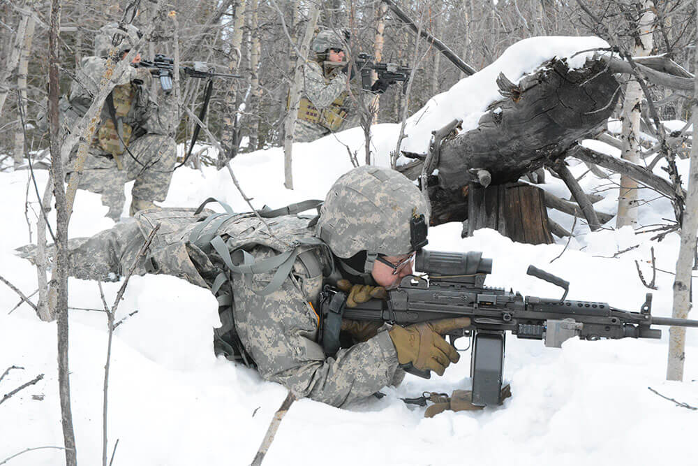 Soldiers with Bravo Company, 1st Battalion, 297th Infantry Regiment, lie ready to assault a bunker on the Donnelly Training Area during a notional attack as part of the training exercise Arctic Eagle 2018.