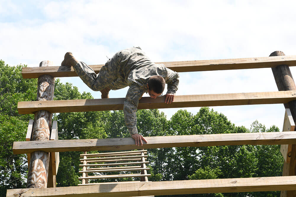 1LT Emily Lilly climbs the Weaver on an obstacle course near Yeager Air National Guard Base. National Guard Bureau photo by Luke Sohl