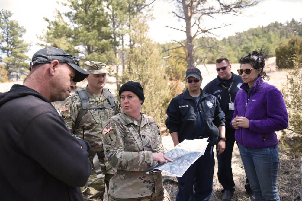 CPT Sabrina Kirkpatrick, environmental officer with the Wyoming Army National Guard discusses with several staff members of local civil authorities and fellow Wyoming Army National Guard officer LTC William Patton a potential breakout of fire in an area of Sawmill Canyon on Camp Guernsey, Wyo. Wyoming Army National Guard photos by SFC Jimmy McGuire