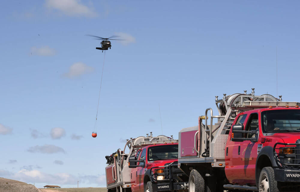 A Wyoming Army National Guard UH-60 Black Hawk helicopter crew from G Company, 2nd Battalion, 211th Aviation Regiment, approaches a drop zone during a two-day fire containment training exercise with Camp Guernsey Fire Department personnel. Wyoming Army National Guard photos by SFC Jimmy McGuire