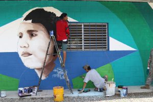 A local El Salvadoran painting company puts finishing touches on the new San Marcos de la Cruz schoolhouse mural. Florida Army National Guard photo by SGT Debra A. Cook