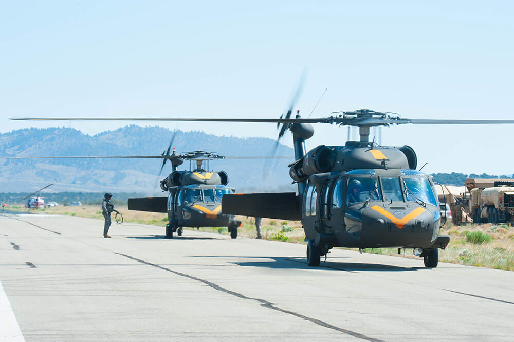 Soldiers of the Colorado Army National Guard prepare to take off from the Spring Creek Fire helibase, Fort Garland, Colo., in UH-60 Black Hawk helicopters equipped with aerial water buckets to support fire suppression efforts in the State this past July. Colorado National Guard photo by TSgt Dixie Manzanares