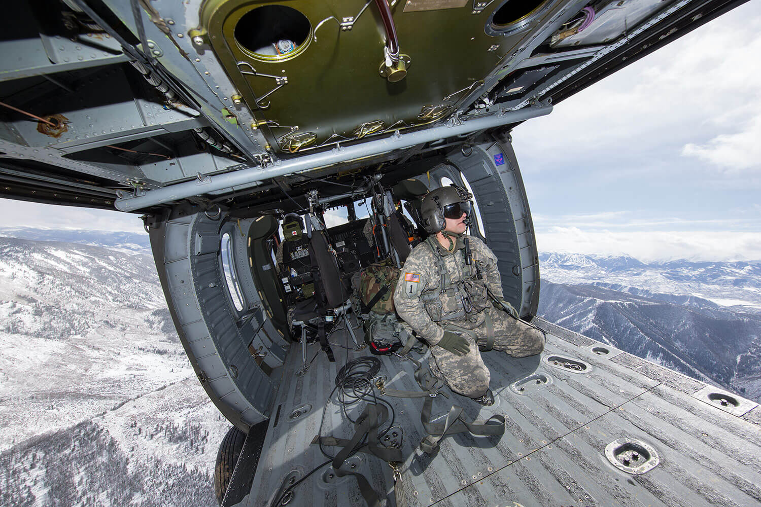 SGT Vincent Lindelin, Colorado Army National Guard, sits in the back of a military helicopter while participating in a High-Altitude Army National Guard Aviation Training Site (HAATS) course. Run by full-time Colorado Army National Guard pilots, HAATS is specifically designed to train military rotary-wing pilots and offers a unique training methodology based on aircraft power that is designed to dramatically increase individual and crew situational awareness. Photo courtesy Frank Crebas