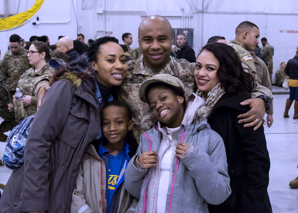 SGT Gary Bennett, 101st Expeditionary Signal Battalion, poses with his Family following the unit’s farewell ceremony at Stewart Air National Guard Base, March, 2018. Approximately 300 members of the battalion departed for further mobilization training at Fort Hood, Texas, before heading overseas in support of Operation Inherent Resolve. New York Army National Guard photo by SGT Jeremy Bratt