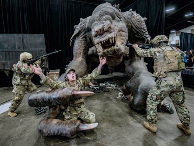 Members of Alpha Company, 1st Battalion, 161st Infantry Regiment, SPC Marco Mayorquin (left) and 1LT Casey Thometz (right), mock-fight a rancor in order to save SGT Brandon Gray as part of a spoof at the 2018 Washington State Toy and Geek Fest in Puyallup, Wash. Washington Army National Guard photo by SGT David Carnahan