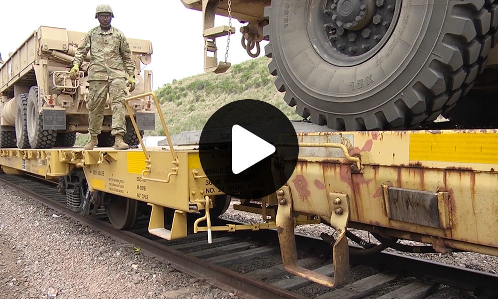 Soldiers with the 1st Battalion, 117th Field Artillery Regiment, Alabama Army National Guard, load and tie down their vehicles for train transport back to Andalusia, Alabama during Operation Western Strike at Camp Guernsey, Wyoming.