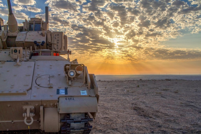 The sun rises above an M2A3 Bradley Infantry Fighting Vehicle at Al-Ghalail Range, Qatar, November 2018. The Mississippi Army National Guard Soldiers of the 2nd Battalion, 198th Armor Regiment, Task Force Spartan, spent the pre-dawn hours staging their Bradley in preparation for a combined arms live-fire drill held as part of Exercise Eastern Action 2019, a command post and field training exercise conducted in partnership by the U.S. Army and the Qatari Emiri Land Forces. Mississippi Army National Guard photo by SPC Jovi Prevot