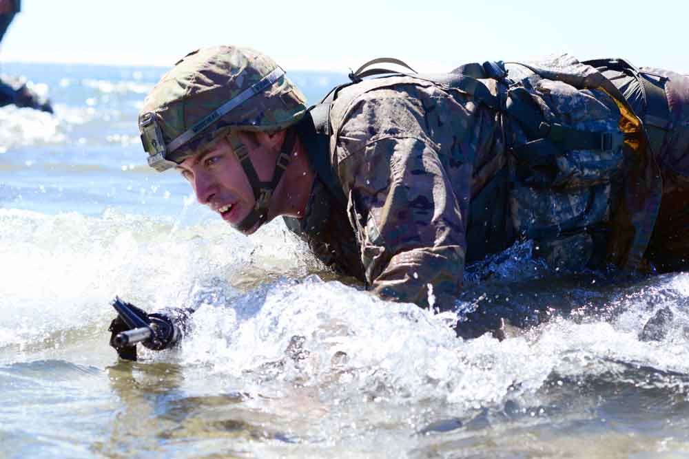 Oregon Army National Guard’s SGT Dane Moorehead of the 82nd Brigade Troop Command, high-crawls to shore in full battle gear as part of the Omaha Beach event during the 2017 Oregon Best Warrior Competition at Camp Rilea, Ore. Oregon Army National Guard photo by SFC April Davis