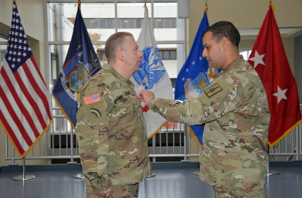 Chief of Staff of the New York Army National Guard COL John Andonie pins CW3 Albert Thiem, Electronic Warfare Officer for the 42nd Infantry Division, during his promotion ceremony at the Division of Military and Naval Affairs Headquarters in Latham, N.Y., Nov. 9, 2018. New York Army National Guard photo by CPT Jean Marie Kratzer