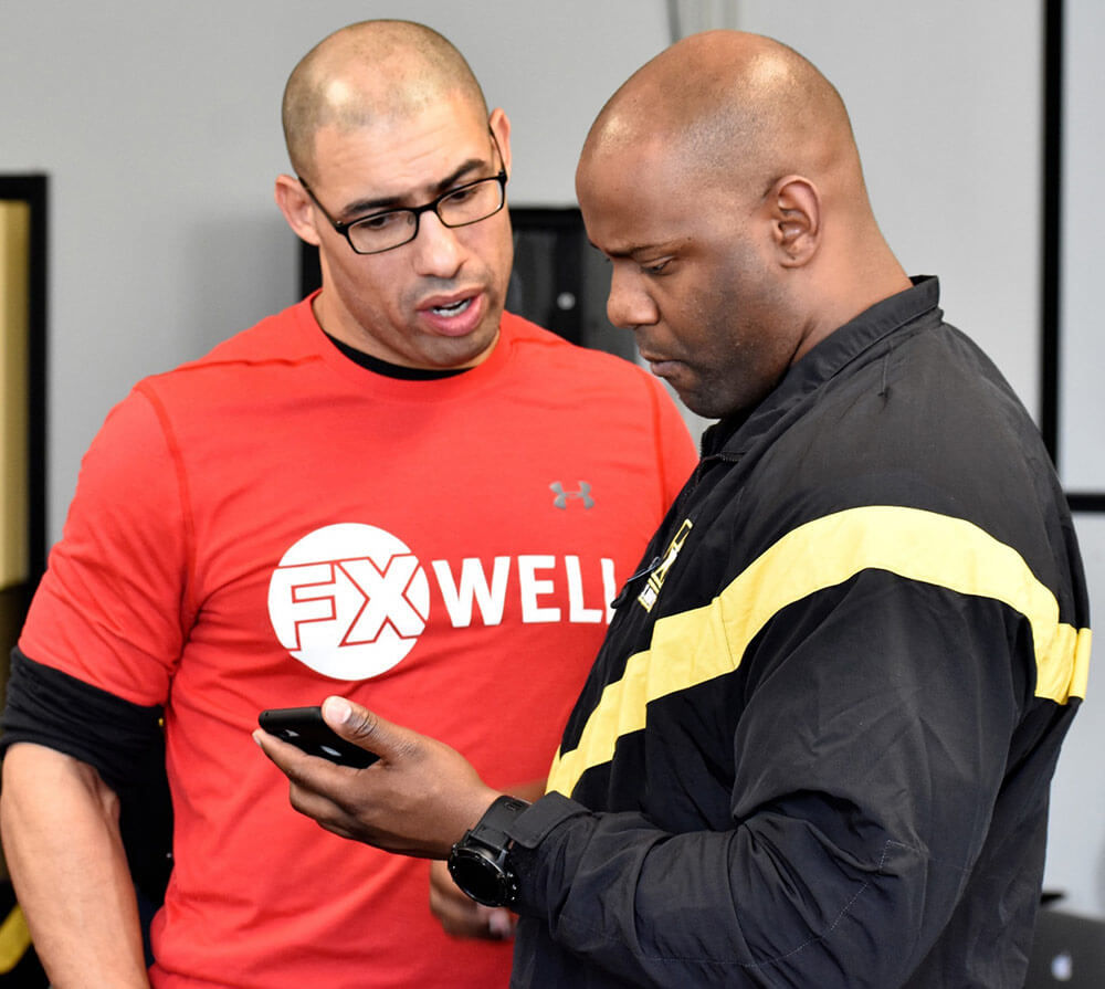 2LT Delvon Anderson assigned to the 629th Military Intelligence Battalion receives instruction from Chad Ayinde, FX Well director, on how to use a fitness app as part of FX Well’s Fit Well training program in which the battalion is participating in preparation for the new Army Combat Fitness Test. Maryland Army National Guard photo by MAJ Kurt Rauschenberg