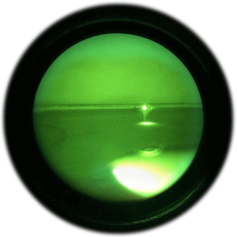 Seen through night vision goggles, Alaska Army National Guard UH-60 Black Hawk crew chief, SPC Jeff Hartmann approaches a hunting party gathered by their campfire on a small island sandbar on the Yukon River in Alaska, May 2019. Photo courtesy Alaska Army National Guard