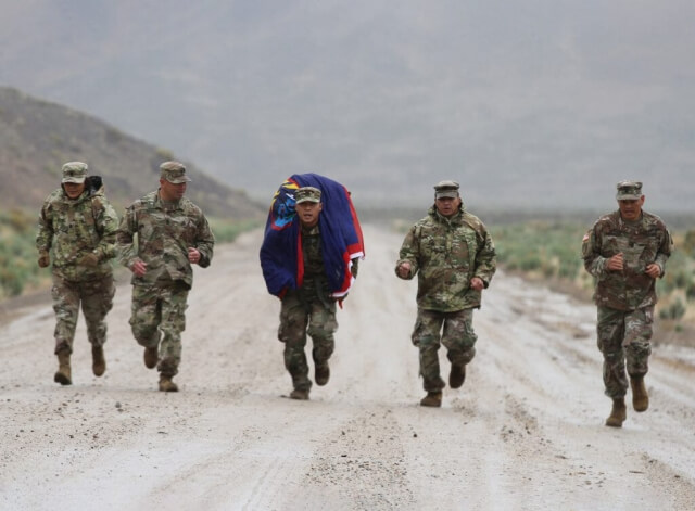 SGT Jermain Mendiola, center, of the Guam Army National Guard, enters the finish line of a grueling 12-mile ruck march May 23 in Hawthorne, Nev., during the 2019 Army National Guard Region 7 Best Warrior Competition (BWC). SGT Mendiola is flanked by CSM Agnes Diaz, Guam National Guard senior enlisted advisor; SGM Bruce Meno; SSG Dino Cruz; and CSM Ron Brantley. The winner advances to the National Guard BWC later this year. California Army National Guard photo by SSG Eddie Siguenza